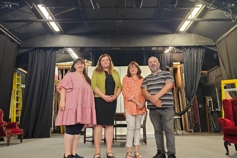 Sioned Williams MS stands with members of Neath Little Theatre on the stage at the now closed venue