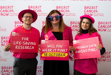 Sioned Williams poses with campaigners from Breast Cancer Now. They are holding a placards that say 