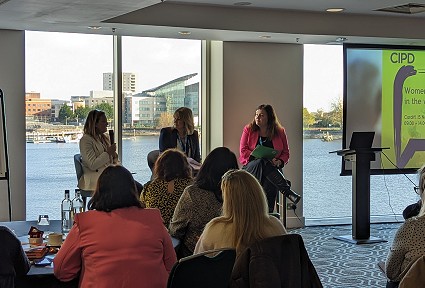 Sioned and two other ladies sitting on stools and speaking in front of and audience