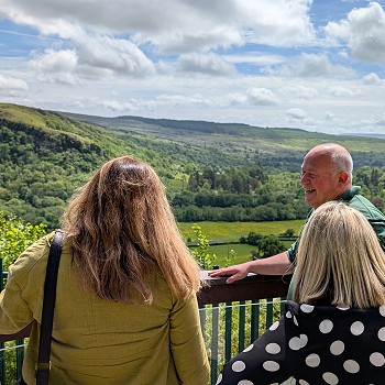 Sioned a Beca gyda'r gwesteiwyr yn edrych ar draws y dyffryn