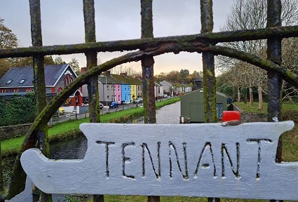 arwydd @tennant' ar ffens o flaen y gamlas