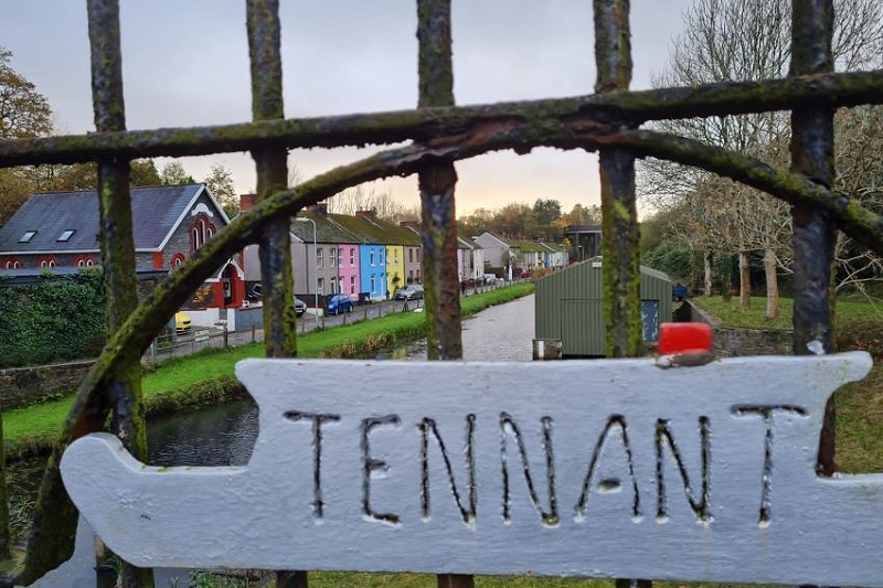 sign 'tennant' on fence in front of canal