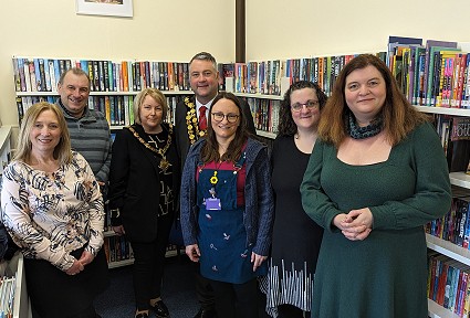 Sioned Williams gyda grŵp o bobl mewn llyfrgell
