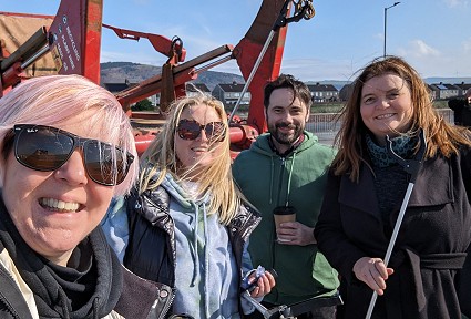 A group of people with litter picking sticks ready to start