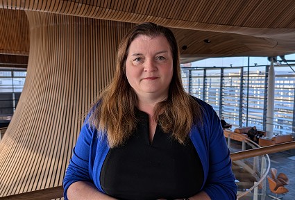 Sioned yn y Senedd atrium siaced las