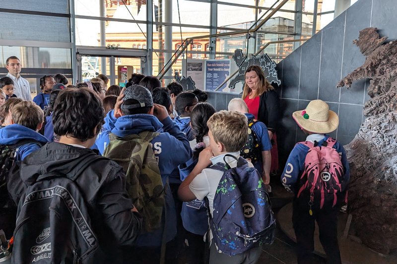 Sioned Williams is talking to pupils from St Thomas community school. They are stood inside the Neuadd inside the Senedd.