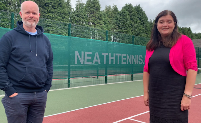 sioned with a man at a tennis court