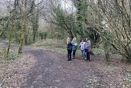 Group of people talking to Sioned Williams in the woods