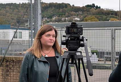 Sioned being interviewed on camera in front of the temporary school buildings