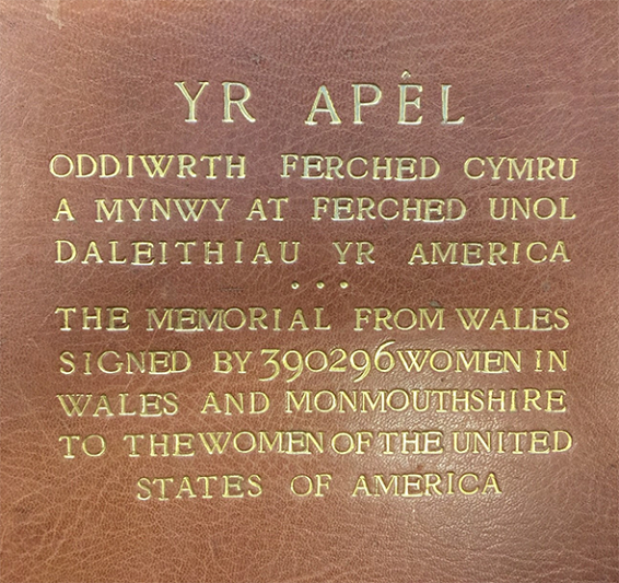 Testun wedi'i ysgythru ag aur ar ledr brown -- Yr Apel Oddiwrth ferched Vymru a mynwy at ferched unol daleithiau yr America . . .  The memorial from Wales signed by 390236 women in waled and monmouthshire to the women of the United States of America