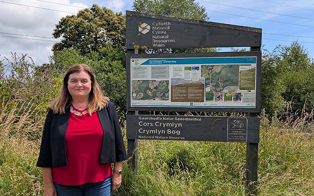 sioned williams next to the crymlyn bog sign